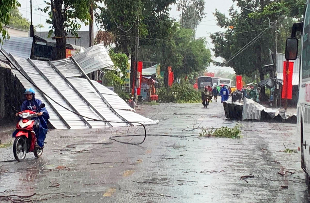 Một mái tôn nhà dân bị lốc cuốn văng xa hàng chục mét, rơi xuống đường giao thông. Ảnh: Nam An