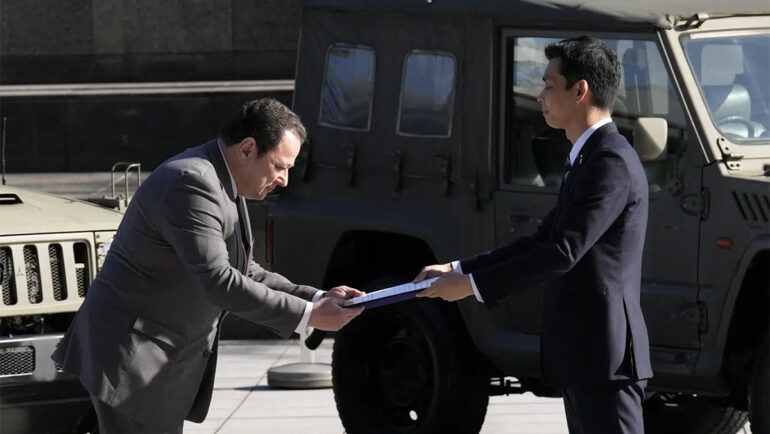 Thứ trưởng Quốc phòng Nhật Bản Toshiro Ino (phải) trao tài liệu cho đại sứ Ukraine Sergiy Korsunsky trong buổi lễ ở Tokyo ngày 24/5. Ảnh: AP