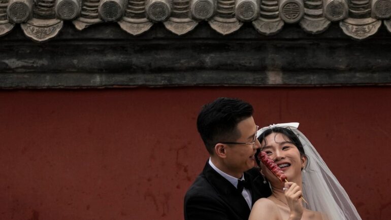 Một cặp đôi đang chụp ảnh cưới ngoài trời ở ngoại ô thủ đô Bắc Kinh, Trung Quốc, tháng 8/2021. Ảnh: AP