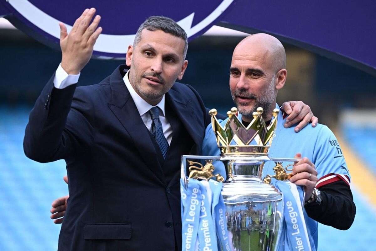 Chủ tịch Khaldoon al-Mubarak chia vui cùng HLV Guardiola trong lễ nhận cup vô địch Ngoại hạng Anh trên sân Etihad ngày 21/5. Ảnh: AFP