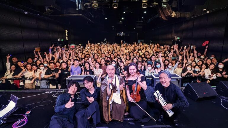 Sư thầy Kanho Yakushiji (giữa) chụp hình cùng ban nhạc và người hâm mộ sau buổi biểu diễn ở Thâm Quyến hôm 16/5. Ông tiếp tục hát ở Quảng Châu (17/5), Hàng Châu (18/5), Thượng Hải (20/5), Bắc Kinh (23, 24/5). Ảnh: Instagram Kanho Yakushiji