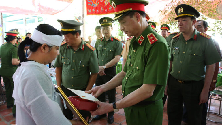 Trung tướng Nguyễn Duy Ngọc, Thứ trưởng Công an, trao quyết định thăng quân hàm cho gia đình trung tá Nguyễn Xuân Hào, hôm 23/4. Ảnh: Thúy Phượng