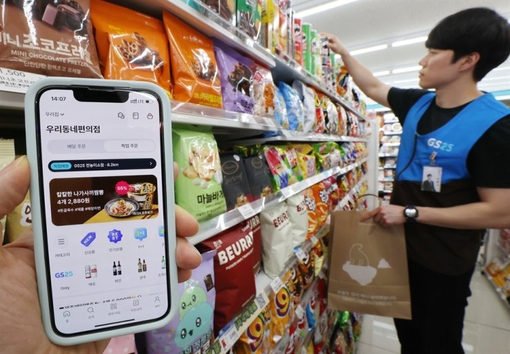 Một nhân viên cửa hàng tiện lợi ở Seoul đang sắp xếp hàng hóa trên kệ, ngày 5/5. Ảnh: Yonhap