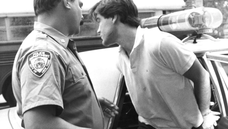 Robert Chambers bước ra khỏi xe cảnh sát với những vết xước rõ ràng trên mặt sau khi bị bắt vì tội giết Jennifer Levin. Ảnh: New York Post