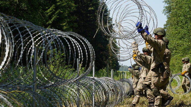 Binh sĩ Litva bố trí dây thép gai ở biên giới với Belarus tại Druskininkai hồi tháng 7/2021. Ảnh: Reuters