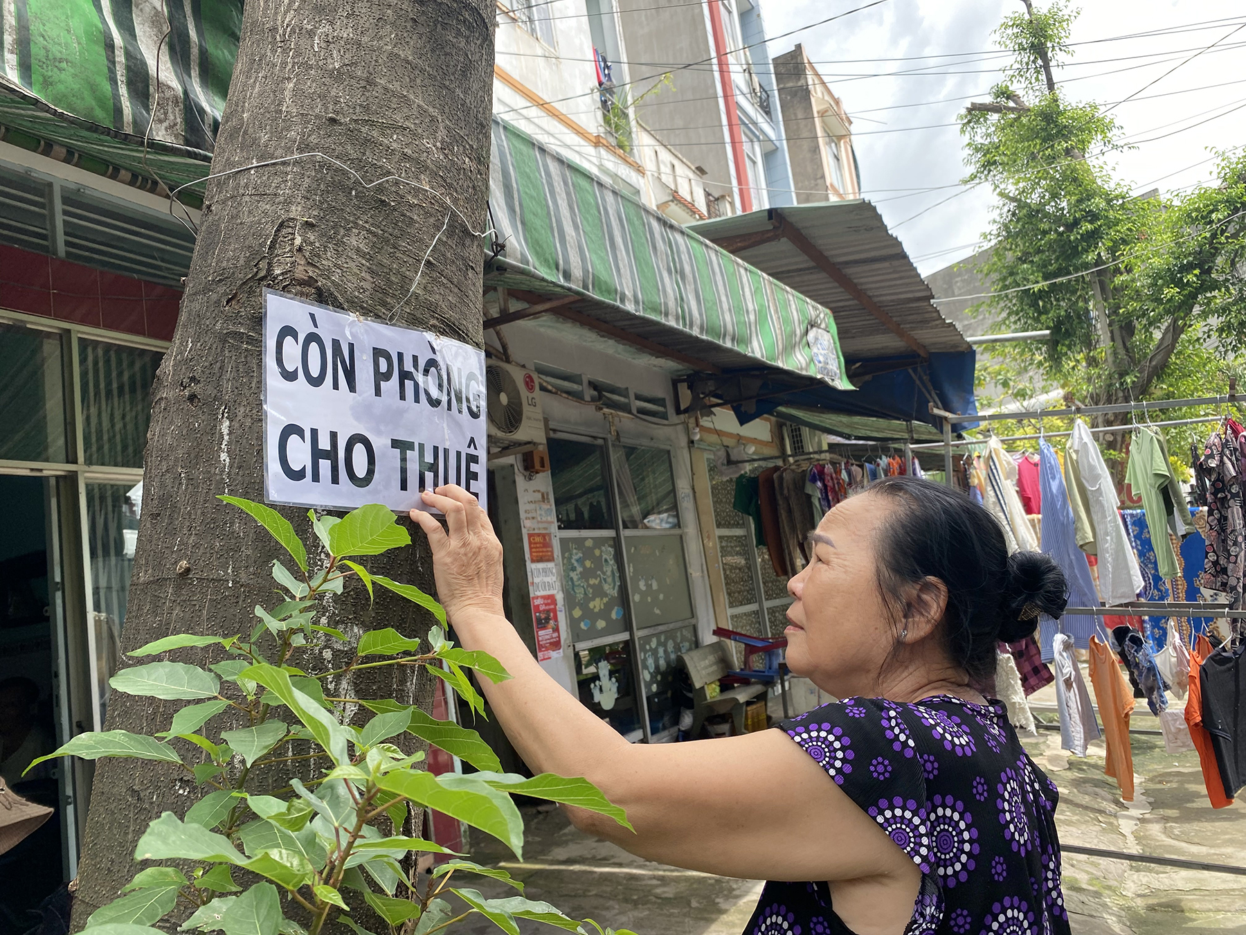 Bà Đỗ Thị Mỳ đóng biển còn phòng trước nhà trọ của mình tại phường Tân Tạo A, quận Bình Tân, trưa 28/7. Ảnh: Ngọc Ngân