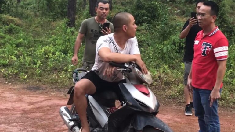 Người dân chặn thanh niên áo trắng hỏi lý do đốt rừng. Ảnh: Vạn An