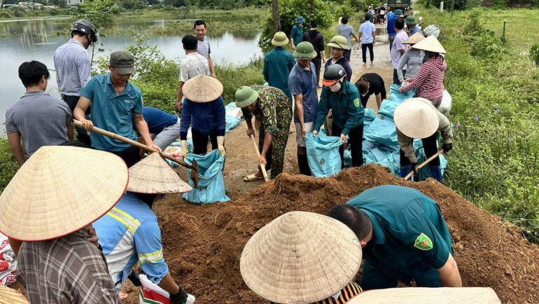 Người dân đắp đê ở huyện Quốc Oai, sáng 28/7. Ảnh: Gia Chính