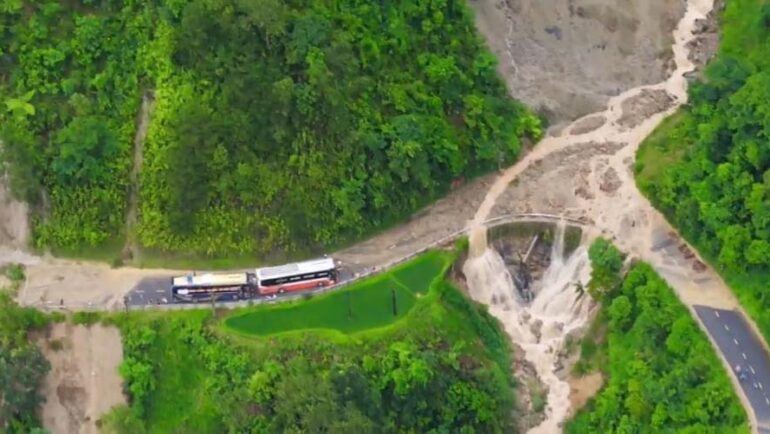 Hai xe khách mắc kẹt giữa hai điểm sạt lở trên quốc lộ 32. Ảnh: Yên Bài toàn cảnh