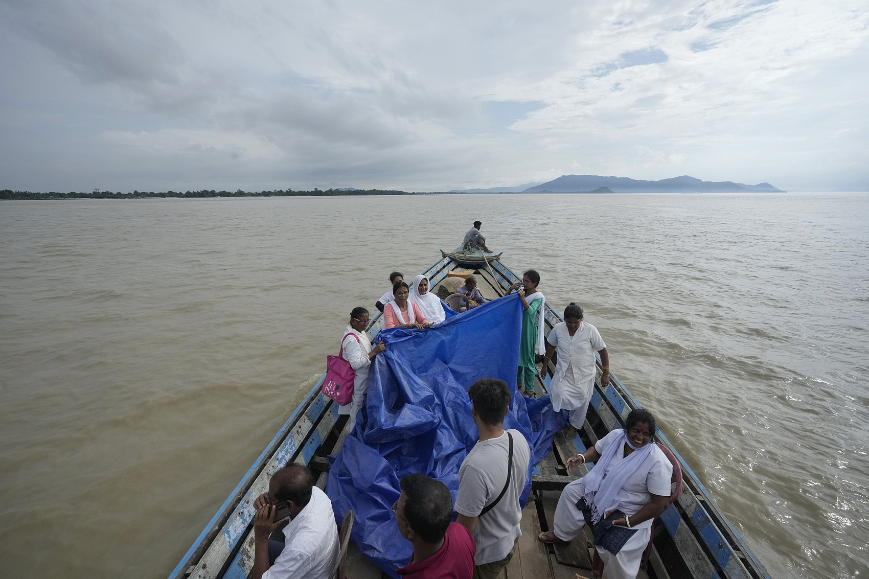 Đội y tế căng bạt và đỡ đẻ cho Jahanara Khatoon trên chiếc thuyền giữa dòng lũ sông Brahmaputra, bang Assam, đông bắc Ấn Độ ngày 3/7. Ảnh: AP