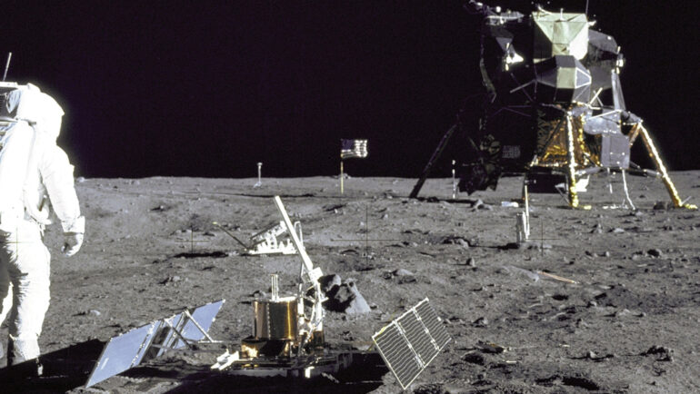 Phi hành gia Buzz Aldrin xem xét đất Mặt Trăng, phía xa bên phải là module Eagle của tàu Apollo 11. Ảnh: NASA