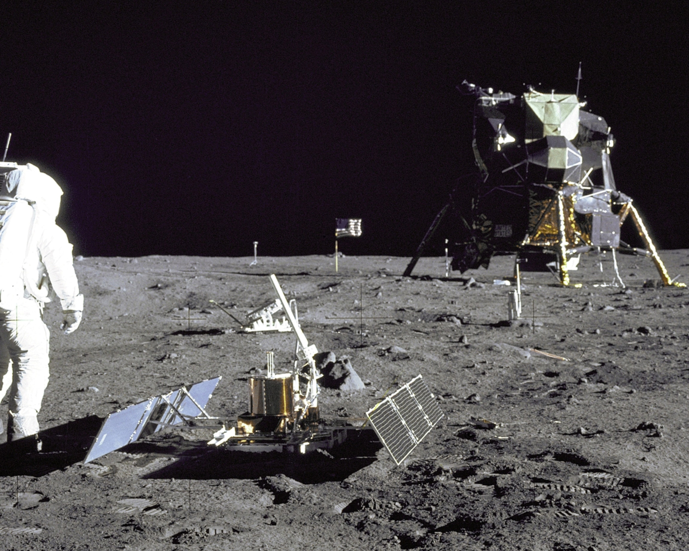 Phi hành gia Buzz Aldrin xem xét đất Mặt Trăng, phía xa bên phải là module Eagle của tàu Apollo 11. Ảnh: NASA