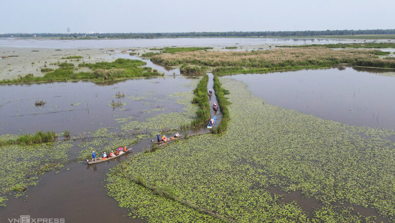 Du khách đi ghe tham quan hồ sông Đầm. Ảnh: Đắc Thành