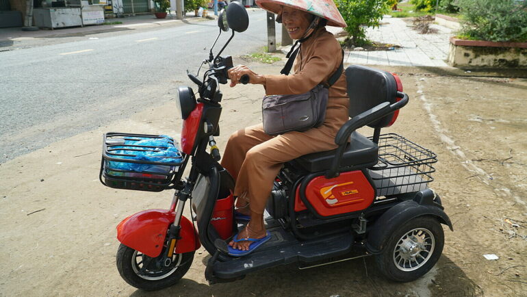 Bà Bảy trên chiếc xe điện ba bánh, ngày ngày bán vé số dạo ở chợ Nước Xoáy, xã Long Hưng A, huyện Lấp Vò. Ảnh: Ngọc Tài