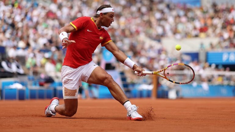 Nadal cắt bóng ở trận gặp Fucsovics, trên sân Philippe Chatrier, Paris hôm 28/7. Ảnh: Reuters