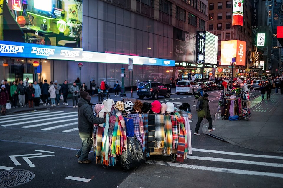 Một người bán hàng trên đường phố New York tháng 12/2023. Ảnh: Reuters