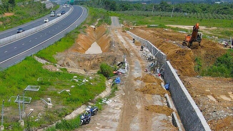 Bức tường được xây ở khu vực ngập tại xã Sông Phan, huyện Hàm Tân, giữa tường và cao tốc sẽ làm hồ điều hòa. Ảnh:  Nguyễn Tư