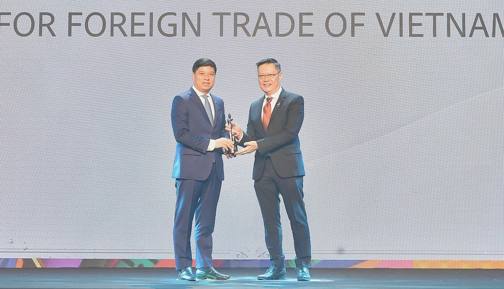 Ông Hồng Quang - thành viên Hội đồng quản trị kiêm Giám đốc khối Nhân sự Vietcombank (bên trái) nhận cúp vàng Harmonia từ ban tổ chức HRAA. Ảnh: Vietcombank