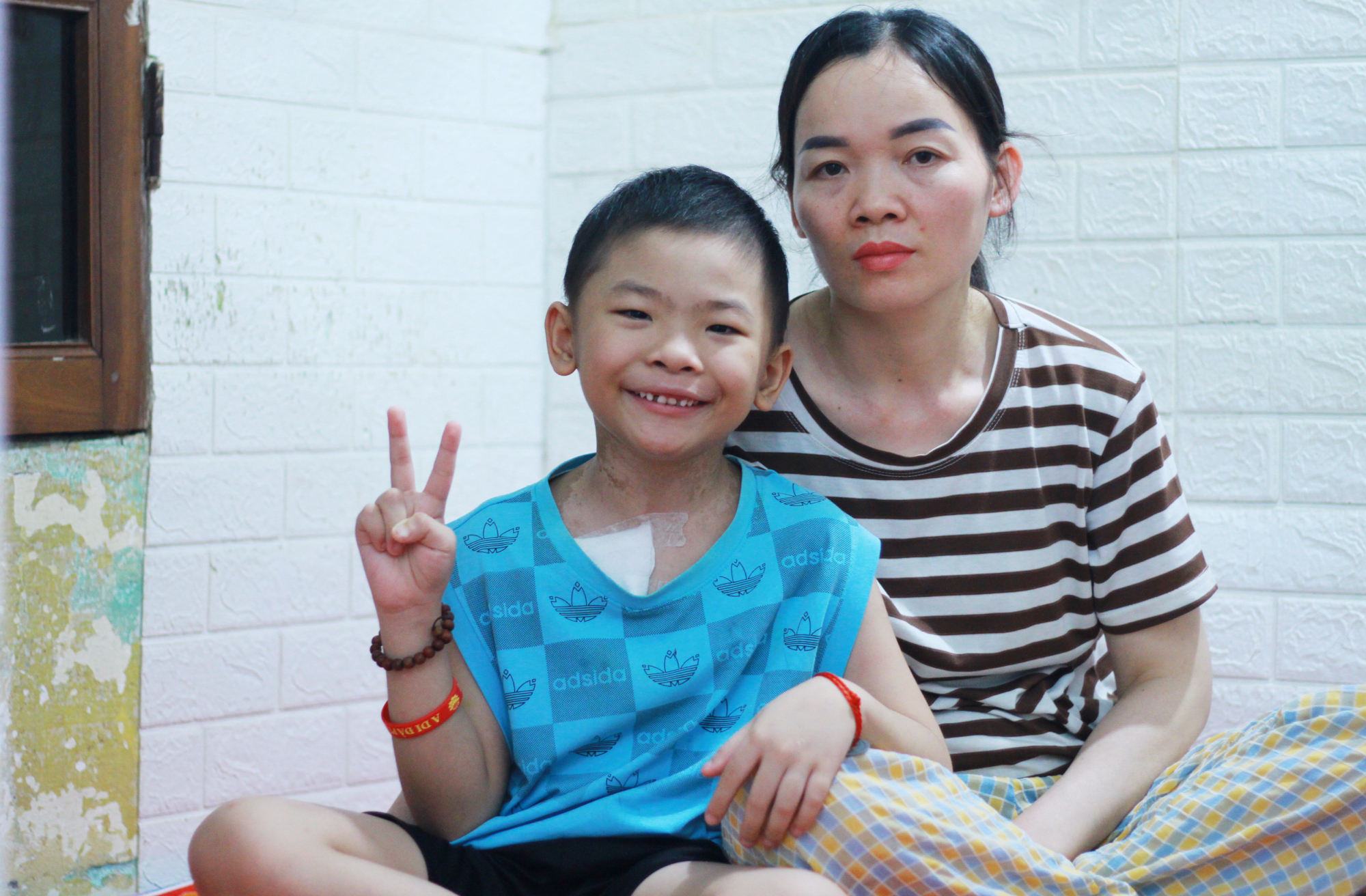 Chị Vi Thị Hương và con trai Cao Xuân Đức được cho ở miễn phí trong khu trọ ở gần Bệnh viện K Tân Triều, chiều 30/7. Ảnh: Phan Dương