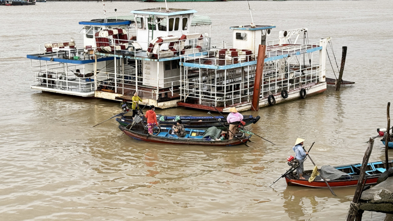 Ba chiếc phà ngưng chạy, trong khi nhiều xuồng nhỏ đưa rước khách qua lại sông Cần Thơ. Ảnh: An Bình