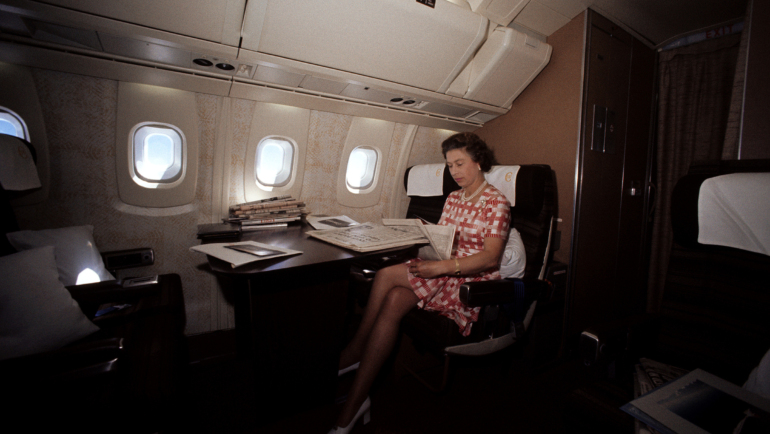 Nữ hoàng Elizabeth II đọc báo trong chuyến bay siêu thanh Concorde về Anh từ Canada, năm 1977. Ảnh: Reuters