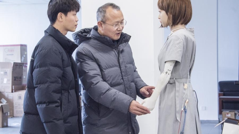 Giáo sư Liu Xiaofeng nói chuyện với một nghiên cứu sinh về robot hình người tại Đại học Hà Hải. Ảnh: Xinhua