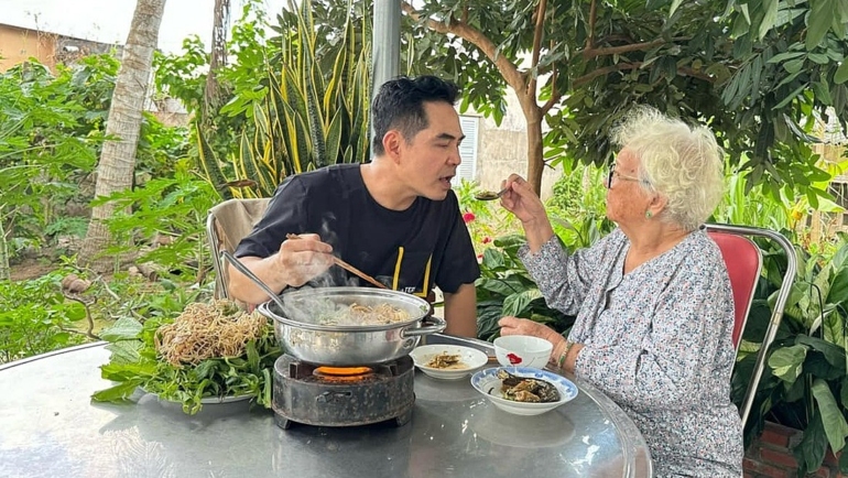 Diễn viên Trung Dũng cùng mẹ quây quầy bên nồi lẩu anh nấu. Ảnh: Nhân vật cung cấp