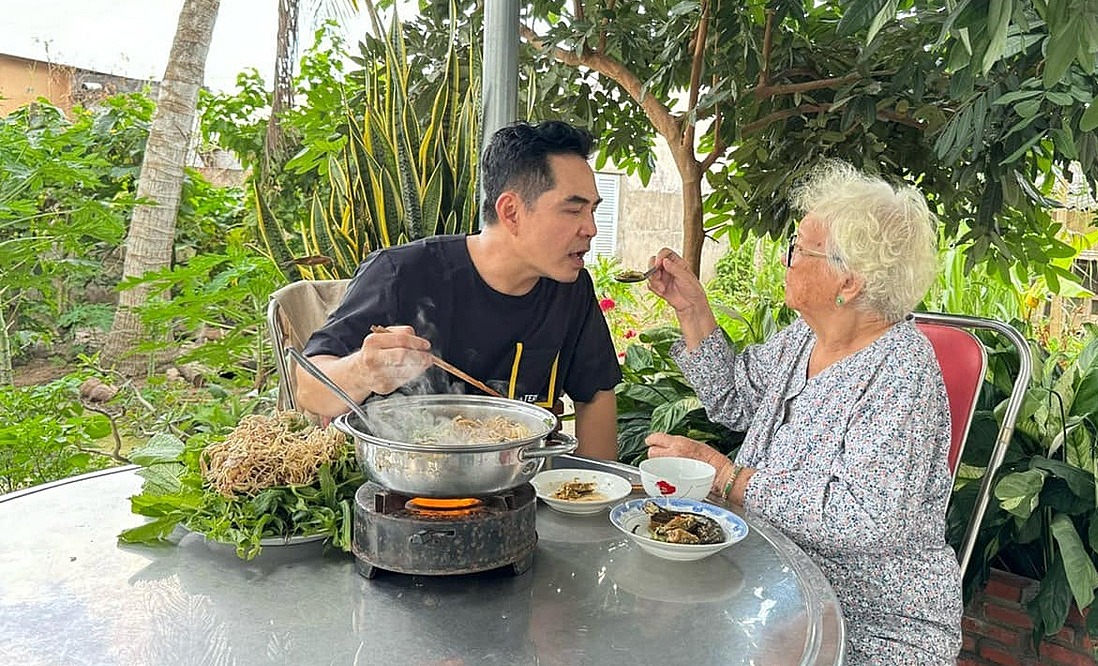 Diễn viên Trung Dũng cùng mẹ quây quầy bên nồi lẩu anh nấu. Ảnh: Nhân vật cung cấp