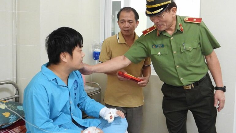 Một trong hai cán bộ công an bị Sách tấn công, bị thương ở tay được Giám đốc Công an TP Đà Nẵng thăm hỏi, động viên. Ảnh: Văn Hồ