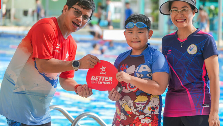 Anh Nguyễn Văn Thủy trao giải Vượt qua chính mình cho một học viên trong Câu lạc bộ Mũ đỏ tại bể bơi quận Thanh Xuân, giữa tháng 7/2024. Ảnh: N.V.T