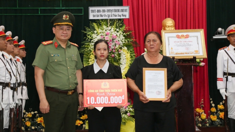 Vợ và mẹ liệt sĩ Trần Duy Hùng nhận bằng Tổ quốc ghi công. Ảnh: Trần Hồng