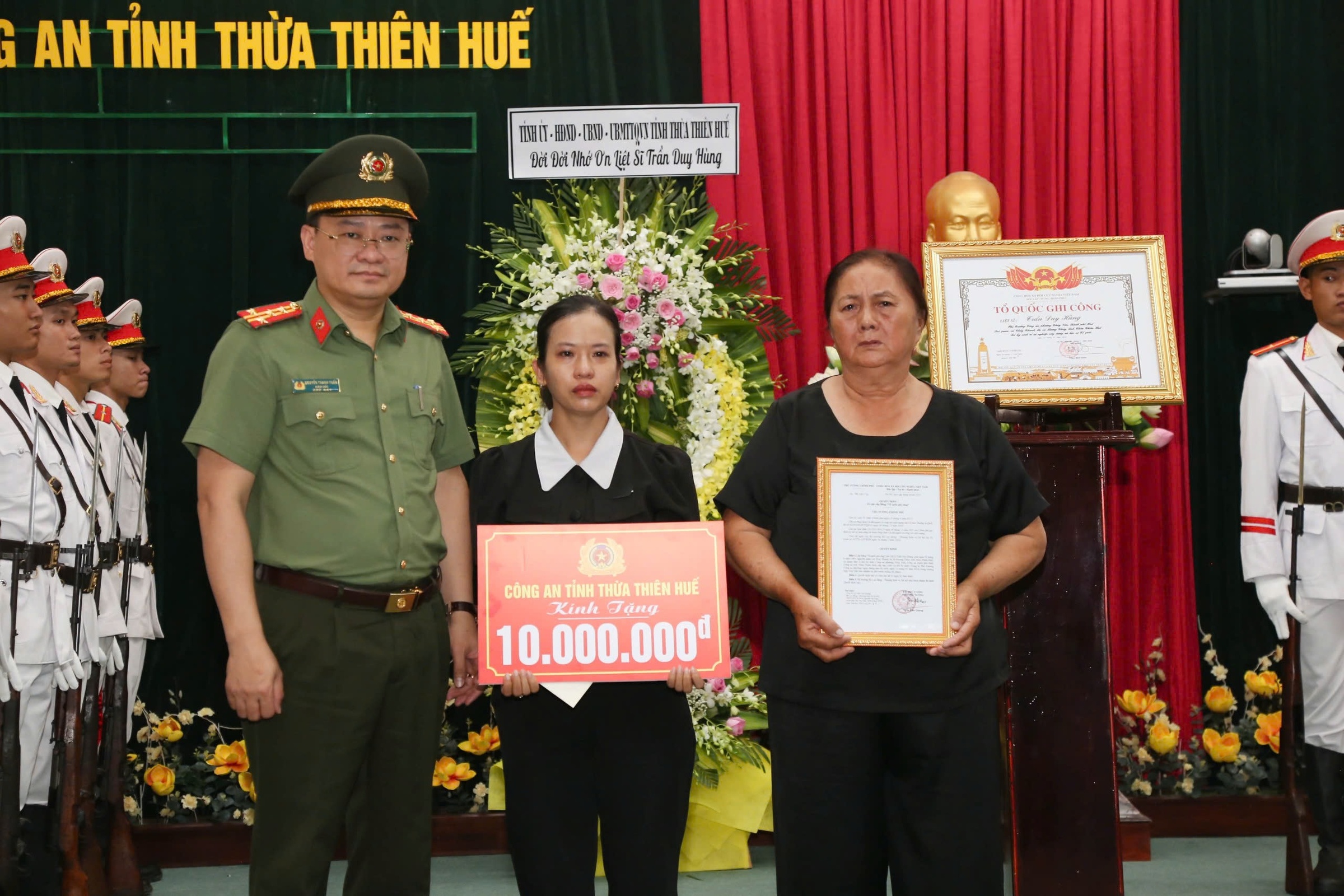 Vợ và mẹ liệt sĩ Trần Duy Hùng nhận bằng Tổ quốc ghi công. Ảnh: Trần Hồng