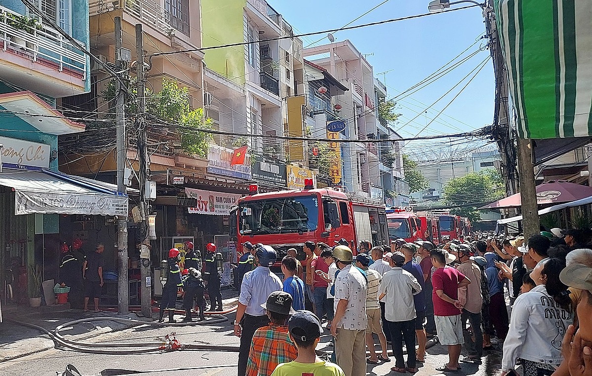 Người dân tập trung kín phía ngoài, trong khi xe cứu hoả nối đuôi nhau tiếp nước cho lính cứu hoả dập lửa. Ảnh: Văn Hồ