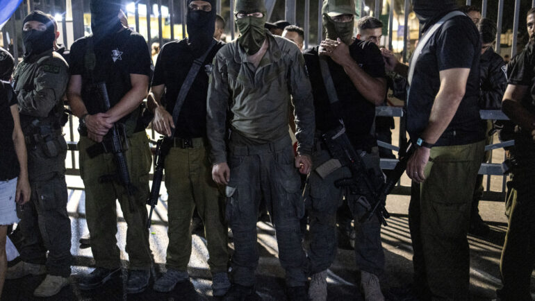 Người biểu tình Israel mang súng vây cổng căn cứ Beit Lid. Ảnh: AFP