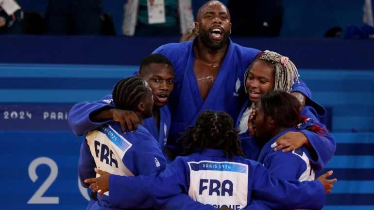 Riner (giữa) và các đồng đội mừng chiến thắng 4-3 cho Pháp trong trận chung kết đồng đội hỗn hợp nam - nữ với Nhật, nội dung thi đấu cuối cùng của môn judo, ngày 3/8. Ảnh: Le Parisien