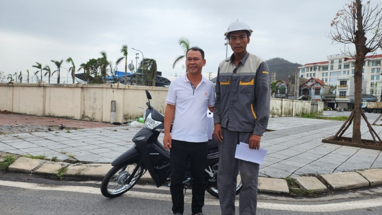 Anh Hoàng Ngô Quý (áo xám) nhận chiếc xe máy mới từ anh Lê Văn Quân (áo trắng) tại thành phố Cẩm Phả, tỉnh Quảng Ninh, sáng 23/9. Ảnh: Người Quảng Ninh
