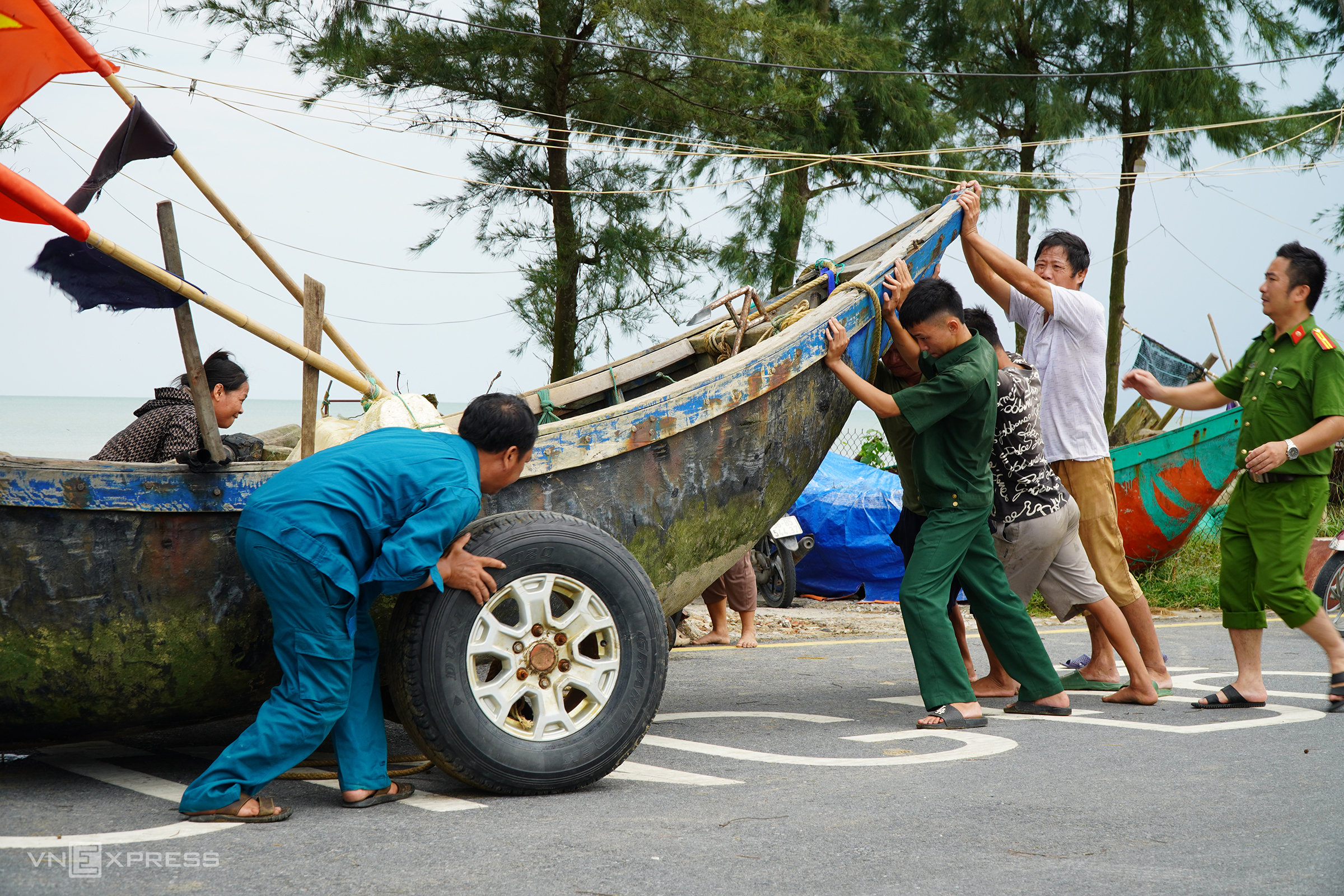 Ngư dân và lực lượng chức năng Sầm Sơn kéo thuyền vào bãi tập kết chiều 6/9. Ảnh: Lê Hoàng