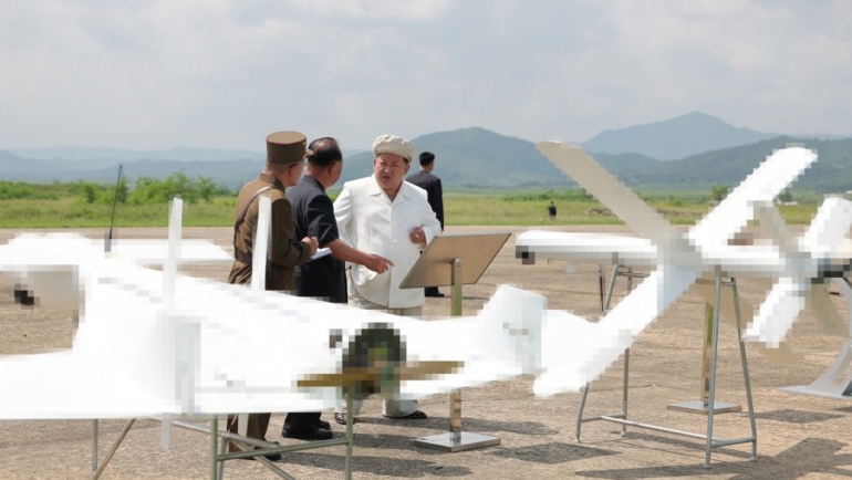 Ông Kim Jong-un bên cạnh hai mẫu UAV tự sát trong chuyến thăm hôm 24/8. Ảnh: KCNA