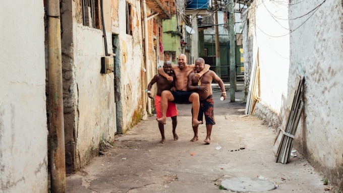 Adriano (giữa) vui vẻ bên hai người bạn trong khu ổ chuột ở Rio de Janeiro. Ảnh: The Players Tribune