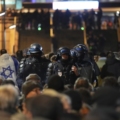 Các cảnh sát theo dõi người hâm mộ trước trận Pháp gặp Israel bên ngoài sân vận động Stade de France, Paris hôm 14/11. Ảnh: AP