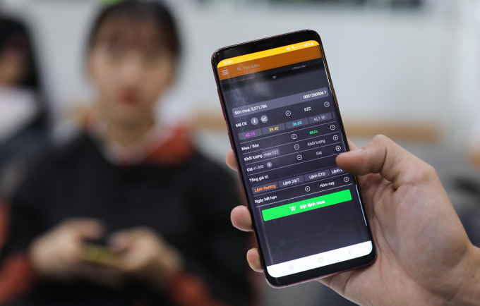 Nhà đầu tư đang thao tác đặt lệnh giao dịch chứng khoán trên ứng dụng di động. Ảnh: Quỳnh Trần