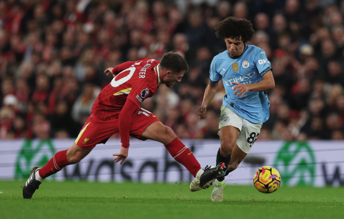 Rico Lewis trong một pha tranh chấp với Alexis MacAllister ở trận Man City thua Liverpool 0-2 tối 1/12. Ảnh: Reuters